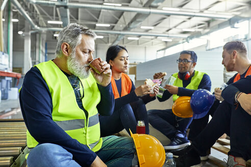 Arbeiter in einer Fabrik machen gemeinsam Mittagspause - ZEDF02136