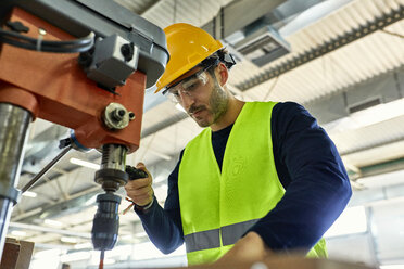 Arbeiter, der eine Bohrmaschine in einer Fabrik bedient - ZEDF02141