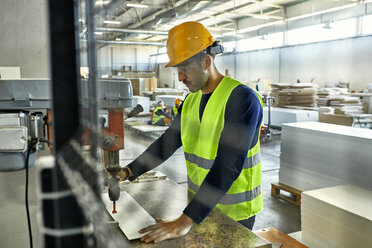 Arbeiter, der eine Bohrmaschine in einer Fabrik bedient - ZEDF02143