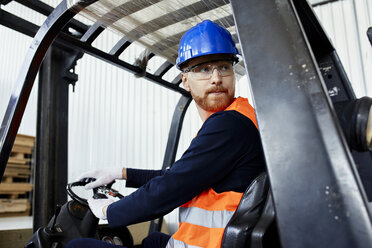 Worker on forklift in factory turning round - ZEDF02149