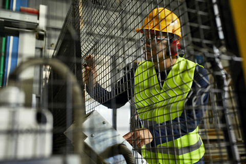 Mann, der eine Maschine in einer industriellen Fabrik bedient, lizenzfreies Stockfoto