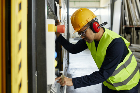 Mann, der eine Maschine in einer industriellen Fabrik bedient, lizenzfreies Stockfoto