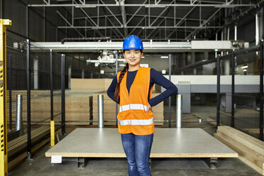 Porträt einer selbstbewussten Arbeiterin in einem Fabriklager - ZEDF02197