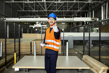 Porträt eines glücklichen Arbeiters mit Tablet in einem Fabriklager - ZEDF02200