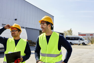 Two workers talking on factory yard - ZEDF02218