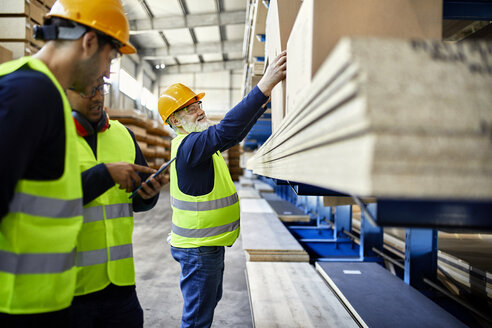 Arbeiter unterhalten sich in einem Fabriklager - ZEDF02228