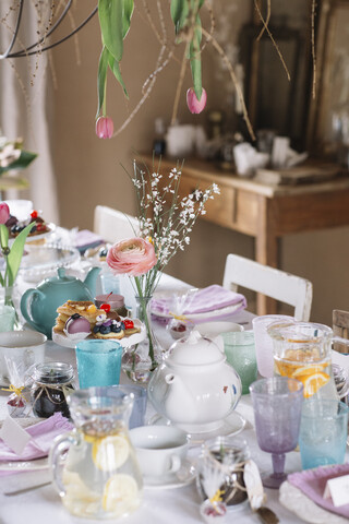Gedeckter Tisch mit Blumendekoration zur Frühlingszeit, lizenzfreies Stockfoto