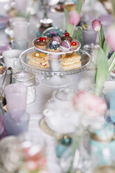 Laid table with pastries on cake stand and floral decoration at springtime - ALBF00863
