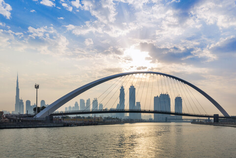 Vereinigte Arabische Emirate, Dubai, Fußgängerbrücke und Skyline am Dubai Creek, lizenzfreies Stockfoto