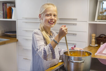 Porträt eines glücklichen Mädchens, das zu Hause Marmelade kocht - HSIF00523