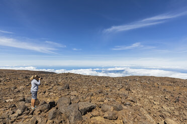 USA, Hawaii, Mauna Kea volcano, female tourist taking a photo of volcanic landscape - FOF10682