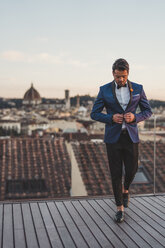 Italy, Florence, stylish man on roof terrace at sunset - FBAF00374