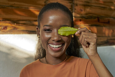 Portrait of happy young woman holding a leaf - VEGF00019