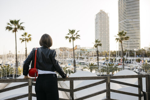 Spanien, Barcelona, Rückansicht einer jungen Frau mit Blick zum Hafen - JRFF03107