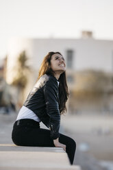 Young woman sitting on a wall - JRFF03118