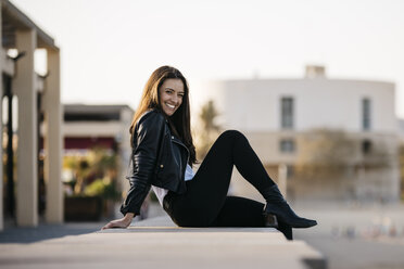 Young woman sitting on a wall - JRFF03119