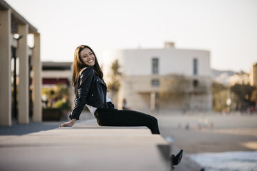 Young woman sitting on a wall - JRFF03120