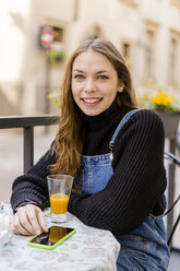 Young woman with smartphone at table - GIOF06280