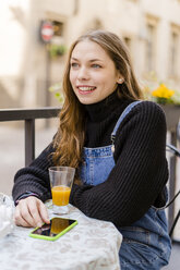 Young woman with smartphone at table - GIOF06281