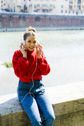 Young woman in Verona, riverside, listening music - GIOF06291
