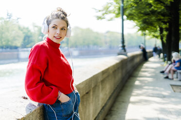 Young woman in Verona, riverside, listening music - GIOF06293