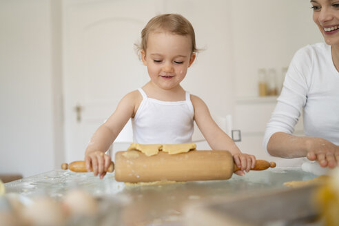 Mutter und kleine Tochter mit Teigrolle machen einen Kuchen zusammen in der Küche zu Hause - DIGF06785