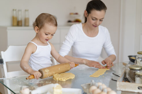 Mutter und kleine Tochter mit Teigrolle machen einen Kuchen zusammen in der Küche zu Hause - DIGF06787
