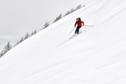 Georgien, Kaukasus, Gudauri, Mann auf einer Skitour beim Abfahren, lizenzfreies Stockfoto