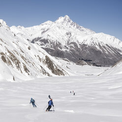 Georgien, Kaukasus, Gudauri, Menschen auf einer Skitour, die bergab fahren - ALRF01499