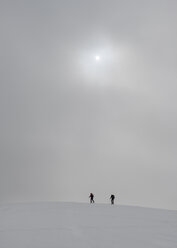 Georgia, Caucasus, Gudauri, people on a ski tour under hazy sky - ALRF01503