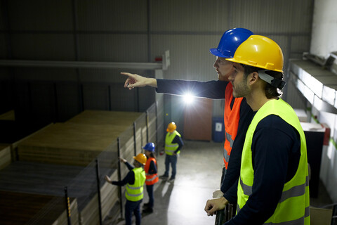 Arbeiter instruieren Kollegen in der Fabrik, lizenzfreies Stockfoto