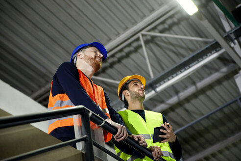 Zwei Arbeiter stehen im oberen Stockwerk einer Fabrik - ZEDF02236