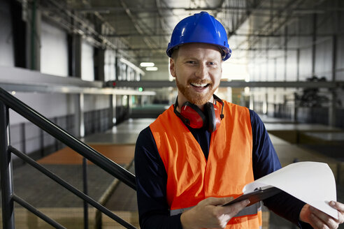 Portrait of happy worker in factory warehouse - ZEDF02245