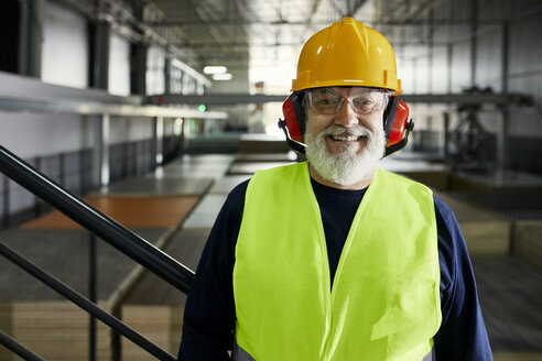 Porträt eines lächelnden reifen Arbeiters in einem Fabriklager - ZEDF02251