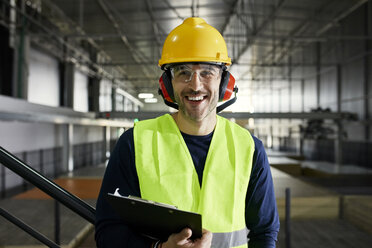 Portrait of happy worker in factory warehouse - ZEDF02252