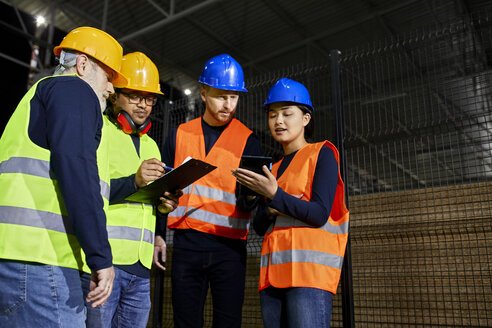 Arbeiter stehen in einem Fabriklager und unterhalten sich - ZEDF02257