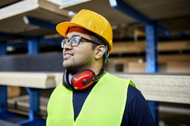 Portrait of smiling worker in factory warehouse - ZEDF02263