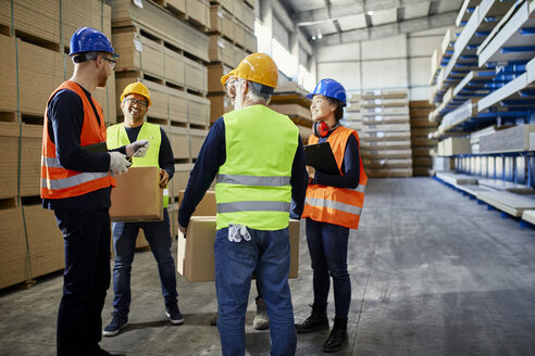 Arbeiter unterhalten sich in einem Fabriklager - ZEDF02271