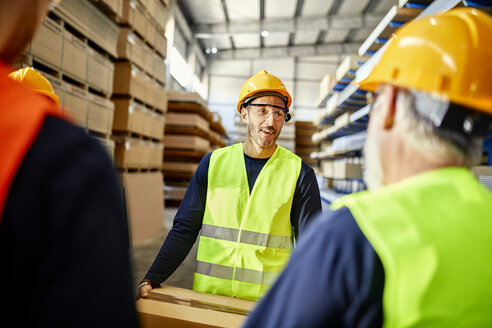 Arbeiter unterhalten sich in einem Fabriklager - ZEDF02273