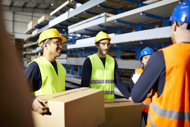 Arbeiter unterhalten sich in einem Fabriklager - ZEDF02274