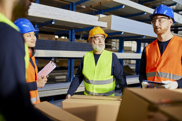 Arbeiter unterhalten sich in einem Fabriklager - ZEDF02275