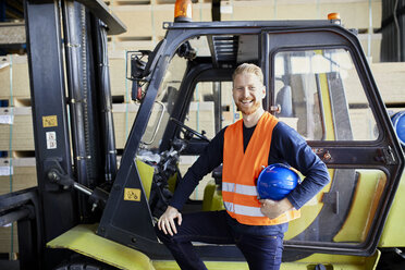 Porträt eines glücklichen Arbeiters am Gabelstapler in einer Fabrik - ZEDF02282