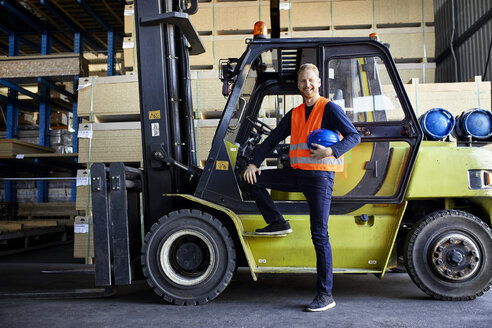 Porträt eines glücklichen Arbeiters am Gabelstapler in einer Fabrik - ZEDF02283