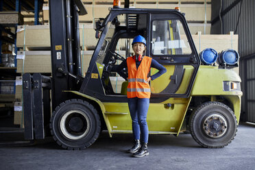 Porträt einer selbstbewussten Arbeiterin an einem Gabelstapler in einer Fabrik - ZEDF02284