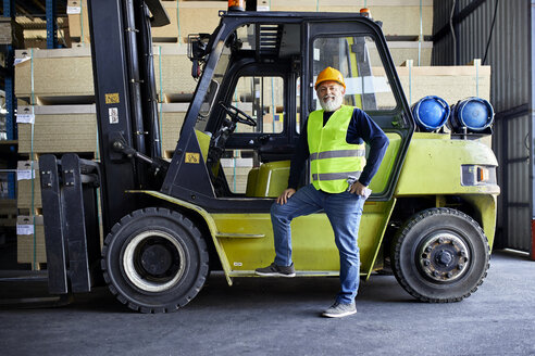 Porträt eines selbstbewussten reifen Arbeiters am Gabelstapler in einer Fabrik - ZEDF02286