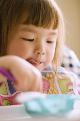 Close up of young girl eating in high chair - BLEF00001
