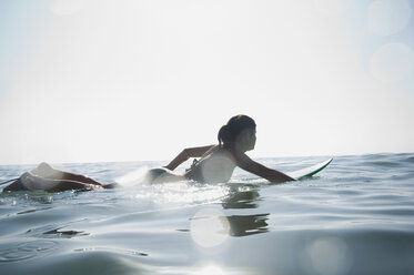 Hispanic girl paddling on surfboard - BLEF00023