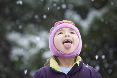 Asiatisches Mädchen streckt Zunge im Schnee heraus - BLEF00034