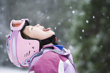 Asiatisches Mädchen streckt Zunge im Schnee heraus - BLEF00035