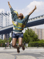Afrikanische Frau springt in der Luft in einer städtischen Umgebung - BLEF00042